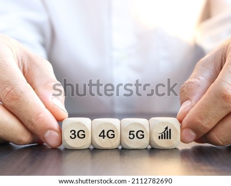 hand hold ing a wooden cube 5G network (5th generation) connects the technology of the future around the world. Wooden cubes switched to 5G
