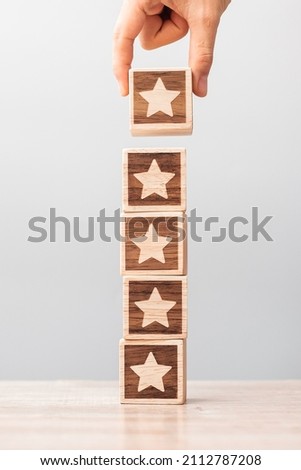 Man hand holding Star block. Customer choose rating for user reviews. Service rating, ranking, customer review, satisfaction, evaluation and feedback concept Royalty-Free Stock Photo #2112787208