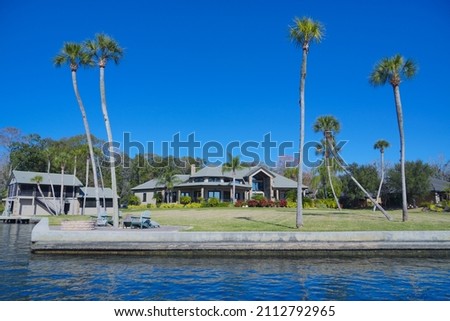 beautiful tree, clear water, and house along homossasa river in winter. 