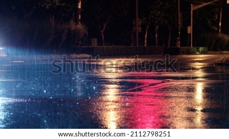 Rainy night in city, the rain was illuminated by the headlights of car.