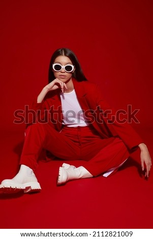 Fashion asian female model in red suit, white boots and sunglasses. Asian fashion Royalty-Free Stock Photo #2112821009