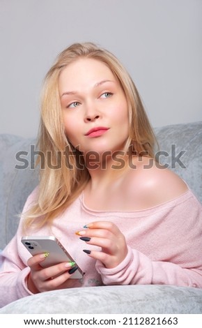 Blonde girl with a smartphone in her hands
