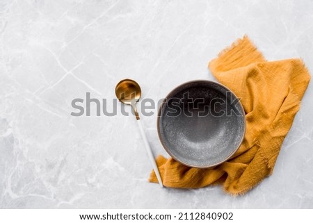 Banner. An empty ceramic plate and towel against the background of a gray concrete table. Space for text. Menu concept for cafes and restaurants.