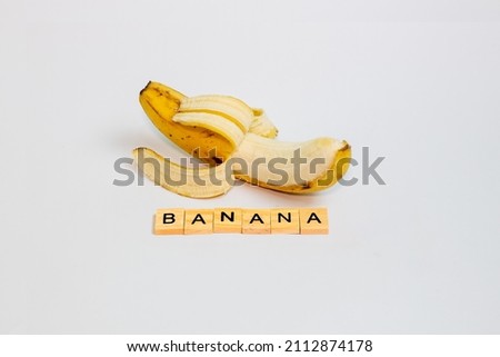 learn to recognize words from fruits, you can see the word "banana" written from the wooden alphabet, isolated on a white background.