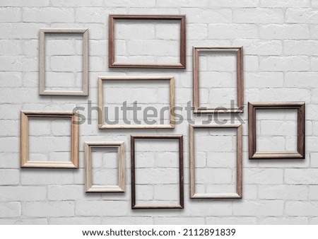 old photo frames on white brick wall