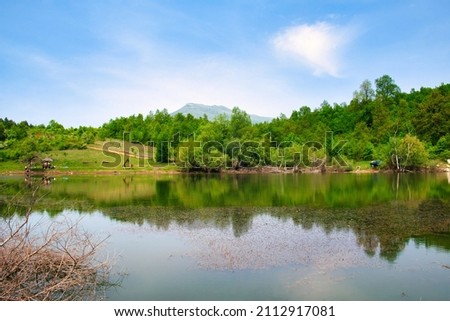 Amazing mountain lake view with reflection on the tranquil water in the national park Rtanj, Serbia  Royalty-Free Stock Photo #2112917081