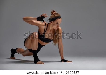 Portrait of female anger, animal instinct, demonstrating their incredible flexibility with the movement of animal flow in the studio on a gray background.