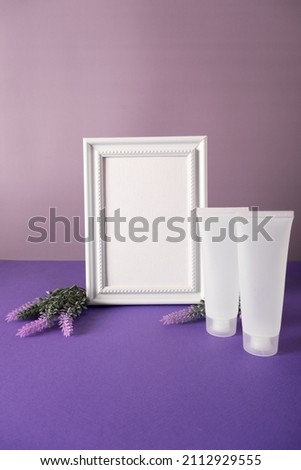 Lavender flowers and leaves creative frame on purple background plastic cosmetic tube mockup. Floral composition and design. New 2022 trending color