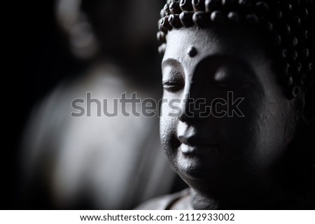 Meditating Buddha Statue on black background.	Close up. 
