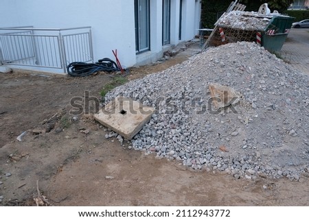 in front of a house the lawn is missing and building material is lying on the ground