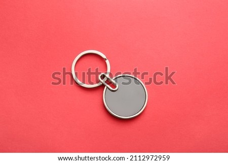 Stylish round keychain on red background