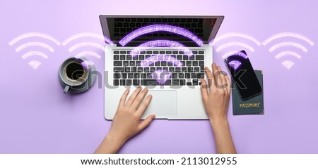 Hands with laptop, mobile phone and wi-fi symbols on color background, top view Royalty-Free Stock Photo #2113012955