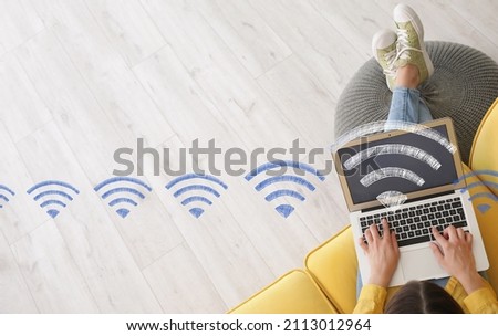 Young woman with laptop using wi-fi at home, top view Royalty-Free Stock Photo #2113012964