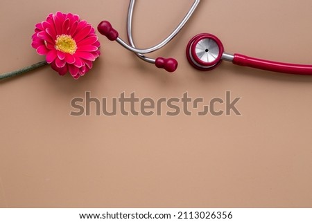 Breast cancer diagnosis with red stethoscope and flower