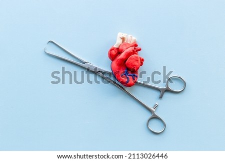 Surgical instruments and heart model. Heart surgery concept Royalty-Free Stock Photo #2113026446