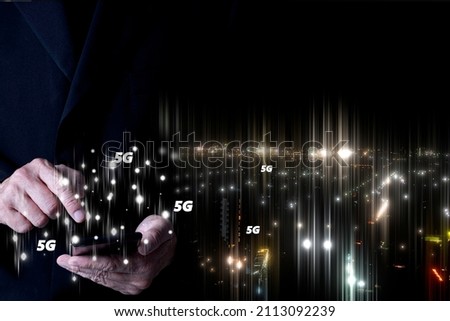 A businessman using a smartphone to connect to 5G high speed internet for data communication and worldwide telemarketing. Business, finance, social and technology concept.