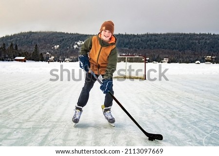 A portrait of happy hockey player on a lake