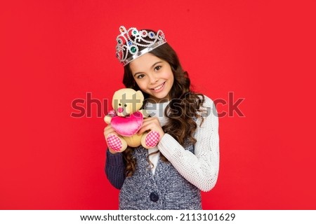 happy child in queen crown. princess in tiara. kid showing bear toy. teen girl wear diadem