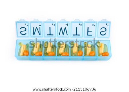 Daily portion of vitamins, drug medicines, tablets, dietary supplements in pill organizer or plactic pill box. A weekly container of tablets, vitamins. Nutritional supplements