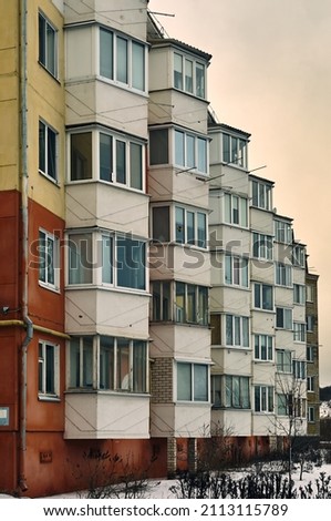 Part of the facade of a multi-storey building, many glazed balconies create an interesting picture, a winter cityscape