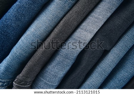 Stack of Various Shades Of Blue Jeans On White Background Denim jeans texture. Denim background texture for design. Canvas denim texture. Blue denim that can be used as background.