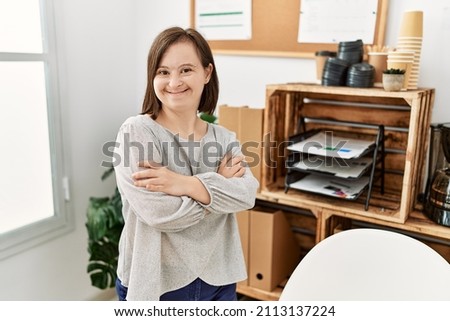 Brunette woman with down syndrome working standing with crossed arms at business office Royalty-Free Stock Photo #2113137224