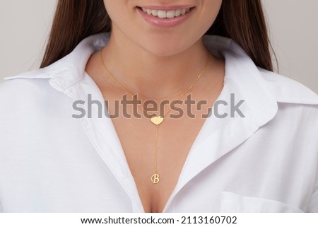 Gold initial necklace on neck of attractive white dress girl. Personalized necklace image. Jewelry photo for e commerce, online sale, social media.