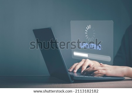 Installing software update process, operating system upgrade concept. Hand using laptop with Installing app patch or app new version updating progress bar on virtual screen. Royalty-Free Stock Photo #2113182182