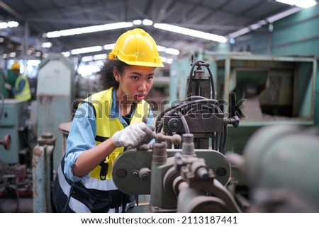 Factory Female Industrial Engineer Works in metal working factory, Inside the Heavy Industry. Portrait of working female industry technical worker or engineer woman working in an industrial. Royalty-Free Stock Photo #2113187441