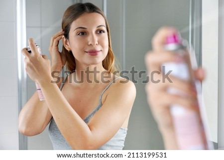 Beauty woman applying dry shampoo on her hair. Fast and easy way to keep hair clean with dry shampoo. Royalty-Free Stock Photo #2113199531