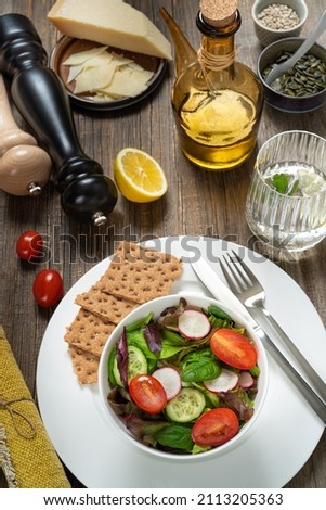 Bowl of salat,pumkin and sunflower seeds,olive oil,fork and knife.Tasty and healthy food concept. Flat lay. Rustic food photography.
