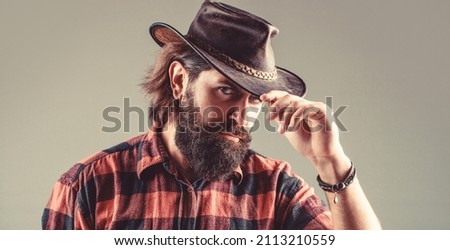 American cowboy. Leather Cowboy Hat. Portrait of young man wearing cowboy hat. Cowboys in hat. Handsome bearded macho. Royalty-Free Stock Photo #2113210559