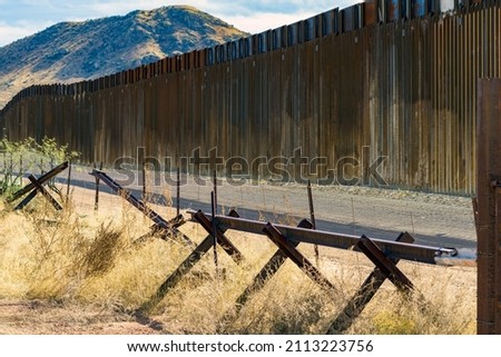 The border wall in southern Arizona that separates the United States from Mexico.  Royalty-Free Stock Photo #2113223756