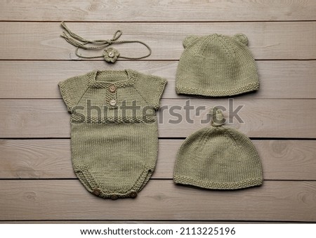 Set of cute baby knitwear for photoshoot on wooden background, flat lay