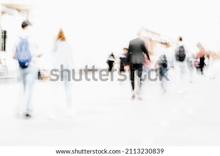 Abstract defocused motion blurred people walking in city street. Urban modern background. Blur effect