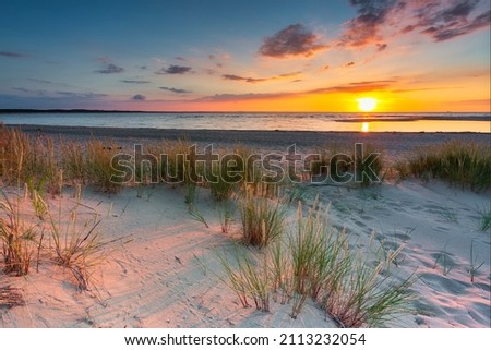 A beautiful sunset on the beach of the Sobieszewo Island at the Baltic Sea. Poland Royalty-Free Stock Photo #2113232054