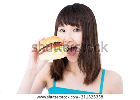 young woman eating hamburger, isolated on white background