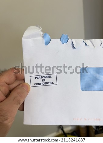 POV male hand holding open envelope with Personnel et confidentiel mark translated as personal and confidential information