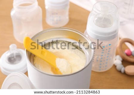 Can of powdered infant formula with scoop on table, closeup. Baby milk Royalty-Free Stock Photo #2113284863