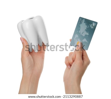 Woman holding ceramic model of tooth and credit card on white background, closeup. Expensive treatment
