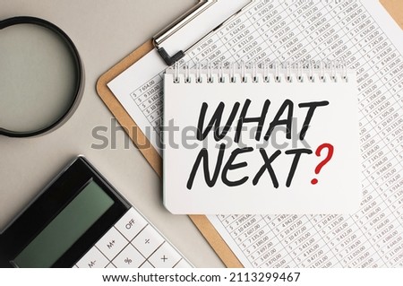 Notepad with text WHAT NEXT, with black marker on white background