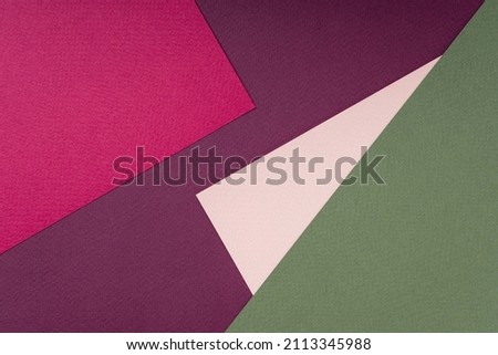 Geometric composition of colored textured paper in burgundy, green and coral. Creative abstract background, flat lay, top view, copy space, mockup. Fashionable minimalistic concept. Color trends