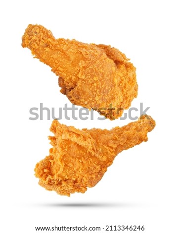Fried chicken legs falling in the air isolated on white background. Royalty-Free Stock Photo #2113346246