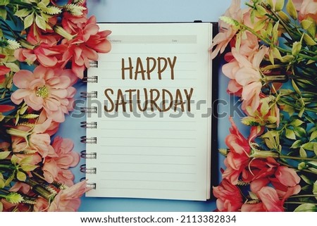 Happy Saturday typography text on paper notebook flat lay on blue background