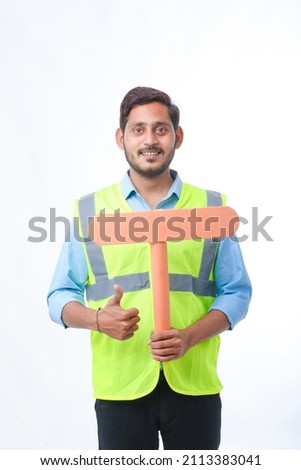 Young indian man holding a empty sign board on white background. construction work concept