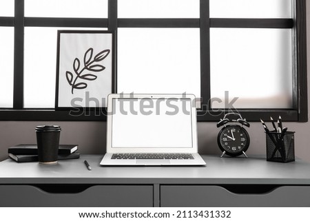 Comfortable workplace with laptop near window in interior of room