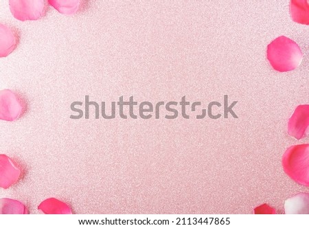 Top view. Background image with a place for an inscription. Bright shiny pink and delicate rose petals around the edges