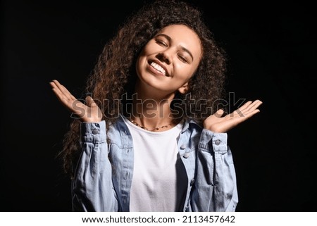 Portrait of happy young woman on black background