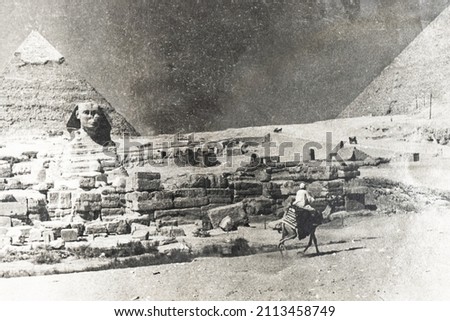 Camel ride at the Sphinx. The Great Sphinx with a pyramid in the background in Giza. Egypt. Black and white photo. An old photo of the pyramids.