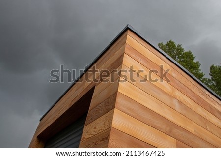 Red cedar wood facade architecture detail low angle view stormy sky background Royalty-Free Stock Photo #2113467425